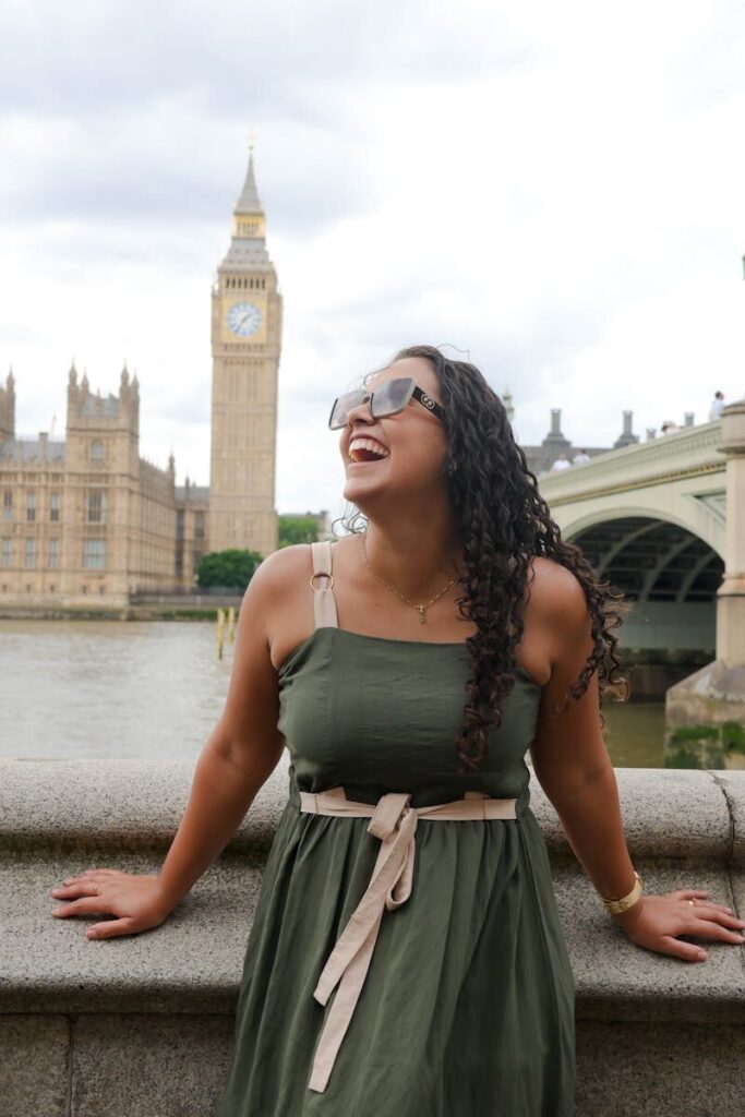 A woman enjoys a sunny day by the River Thames near Westminster Bridge and Big Ben in London.