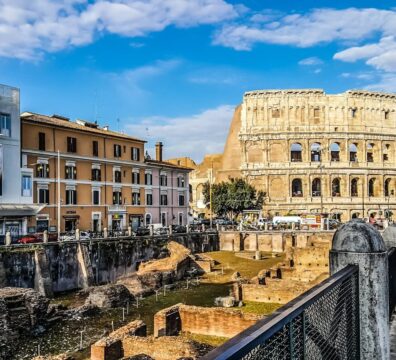 Daylight view of the historic Colosseum in Rome with vibrant city buildings.