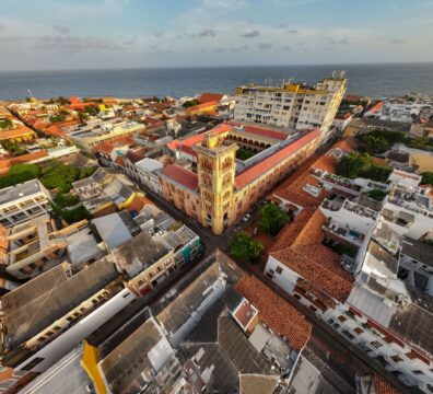 A stunning aerial shot of a coastal town with historic architecture and vibrant rooftops by the sea.