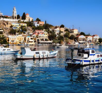 Vibrant houses and boats in the picturesque harbor of Ano Symi, Greece.