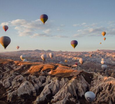 hot air balloons flying over the mountains during daytime