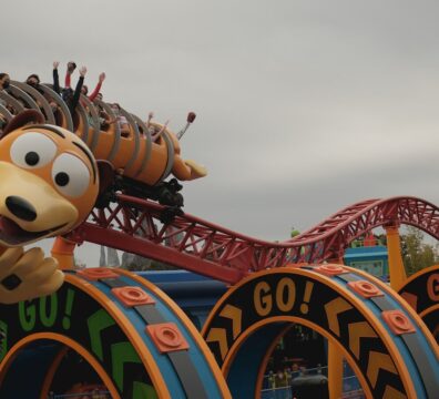 mickey mouse riding on red and blue roller coaster