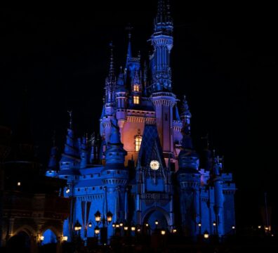 a castle lit up at night with a clock
