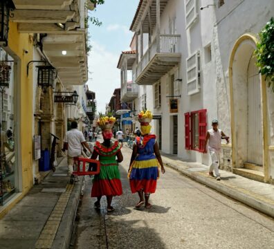 people walking on road between concrete houses during daytime