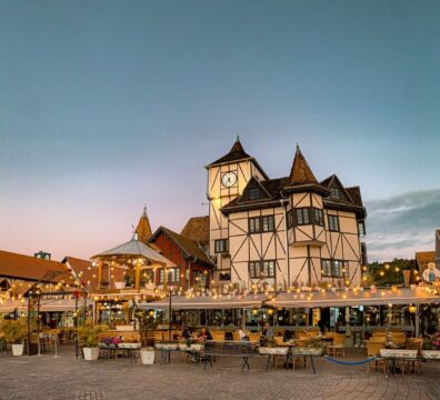 Beautiful twilight scene at Parque Vila Germânica in Blumenau, showcasing charming architecture and outdoor dining.