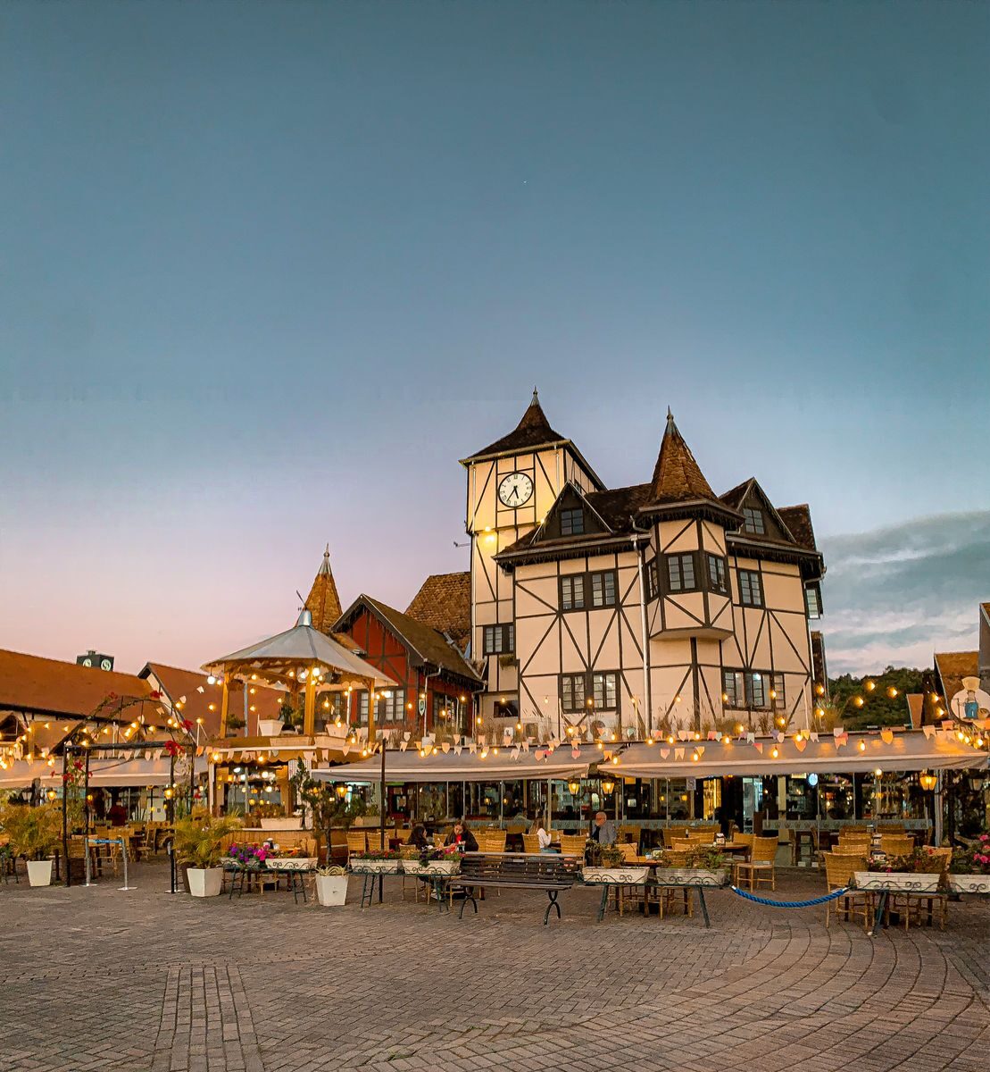 Beautiful twilight scene at Parque Vila Germânica in Blumenau, showcasing charming architecture and outdoor dining.