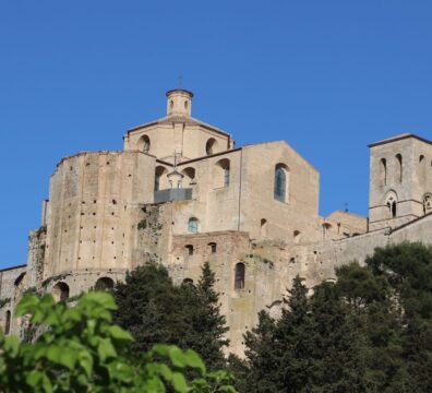 View of ancient abbey against bright blue sky, showcasing architectural details.