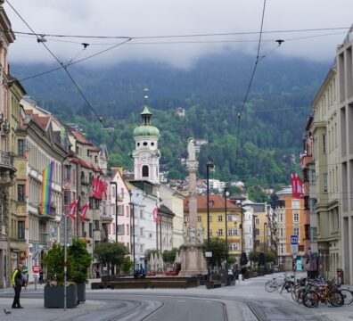 a city street with buildings and a clock tower in the background