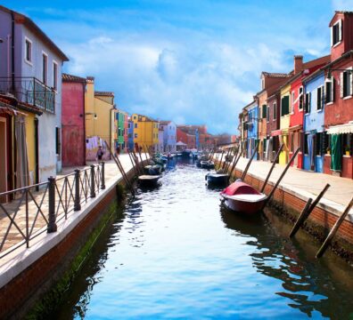 boat on river between buildings during daytime