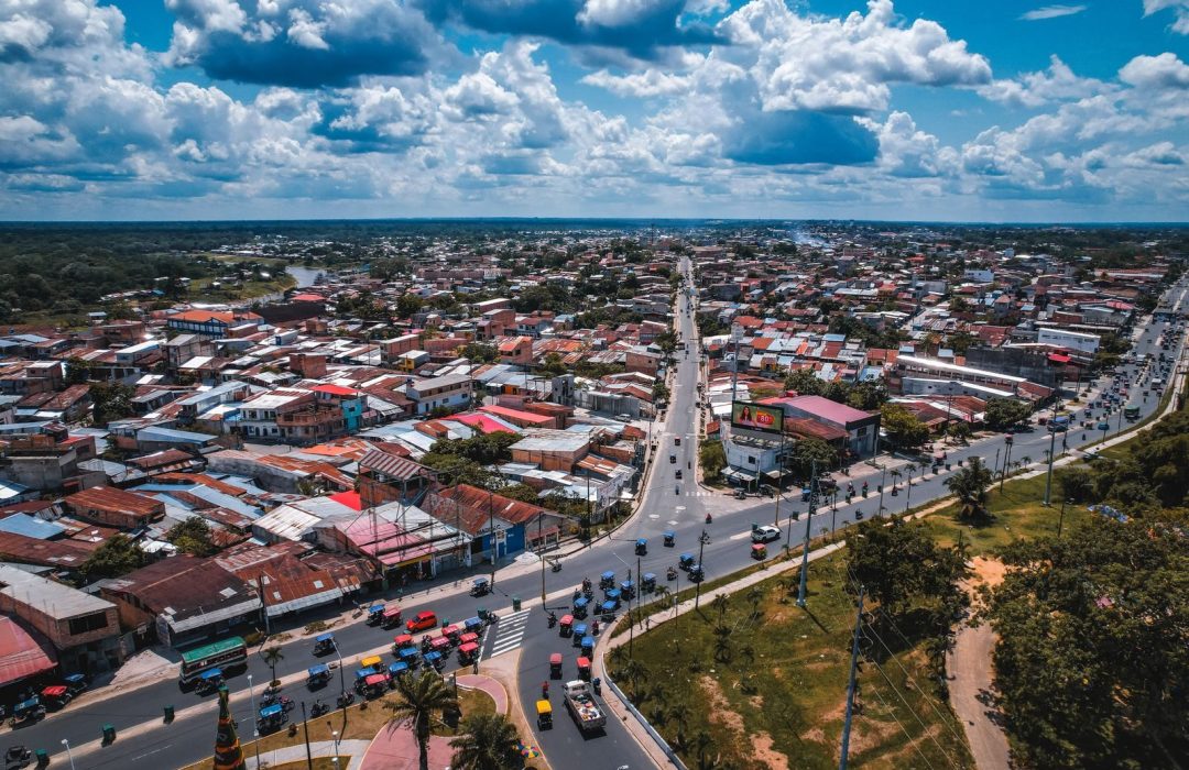Stunning aerial view of Iquitos city with vibrant cityscape and traffic under a cloudy sky.