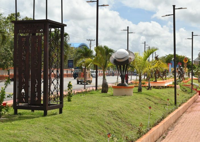a clock tower sitting on the side of a road
