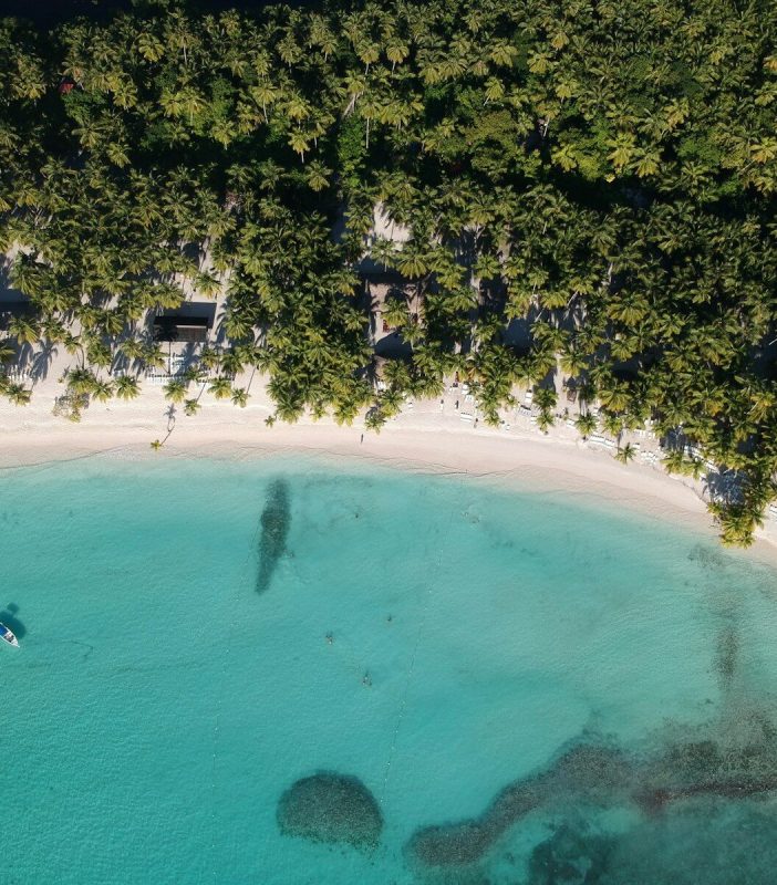 an aerial view of a beach with a boat in the water