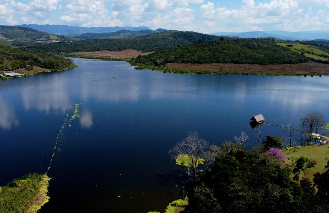a body of water with trees and hills around it